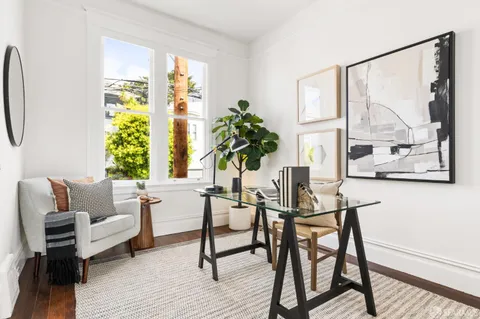 a living room with furniture a widow and white walls