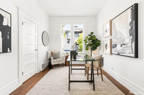 a dining room with furniture potted plants and wooden floor