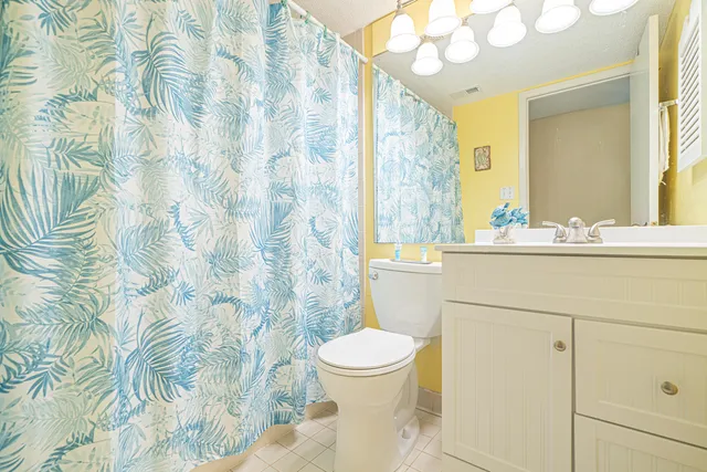 a bathroom with a sink a toilet and shower curtain