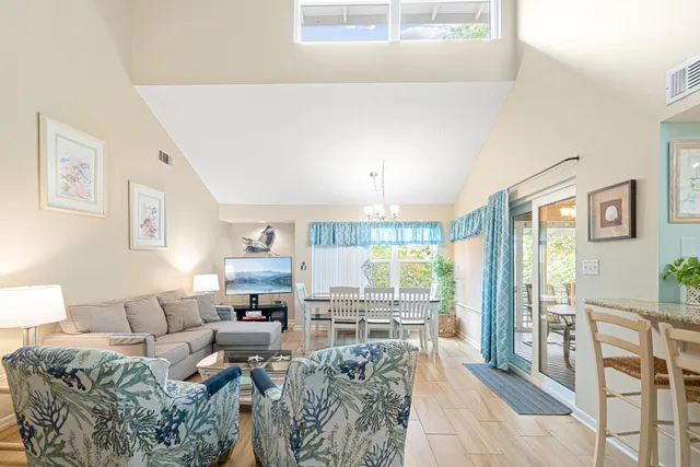 a living room with furniture large window and wooden floor