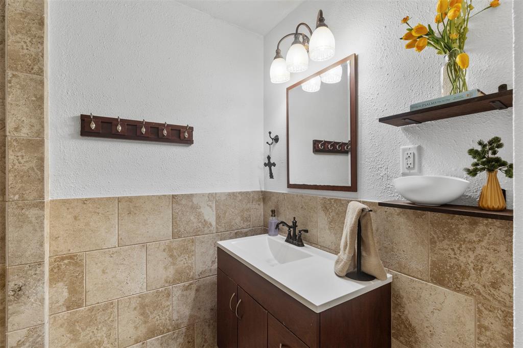 708 East Prairie View Road Crowley, TX 76036 - Photo 11 of 21 Bathroom featuring a dark wood vanity with white countertop, framed mirror, and three-light fixture