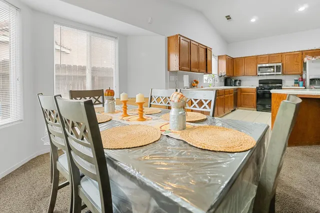 a dining room with furniture and a kitchen view