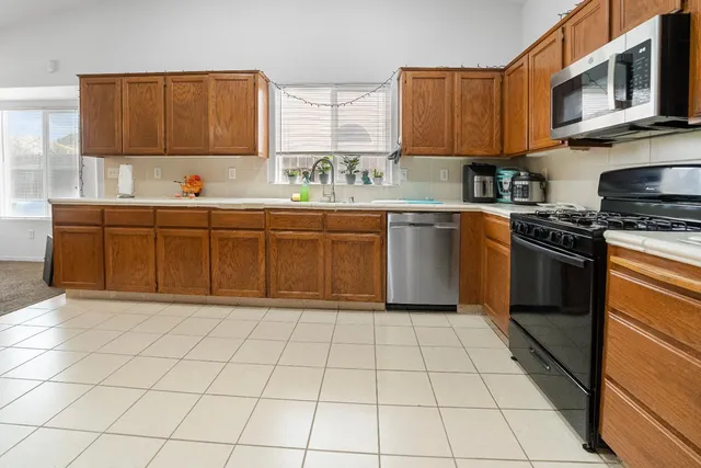 a kitchen with stainless steel appliances a sink window and cabinets