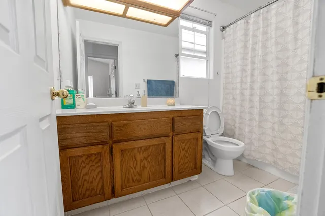 a bathroom with a sink toilet a mirror and shower curtain