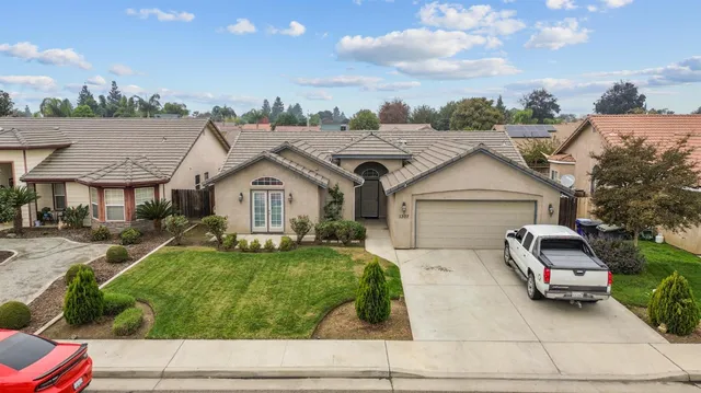 a view of house with garden and tall tress