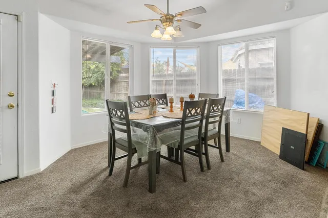 a dining room with furniture and a floor to ceiling window