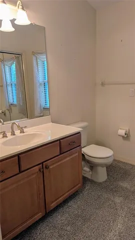 a bathroom with a toilet a sink and mirror