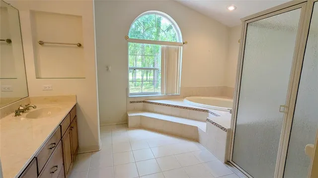 a bathroom with a tub sink and a window