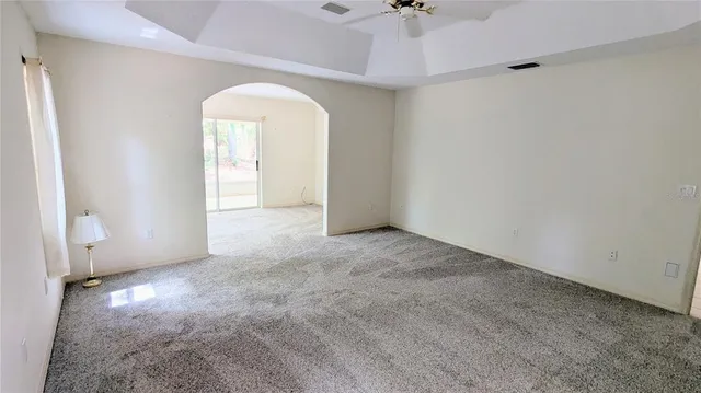 an empty room with a ceiling fan and window