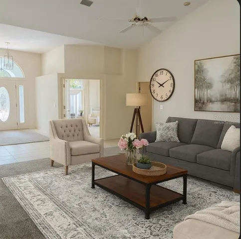 a living room with furniture a rug and wall paintings