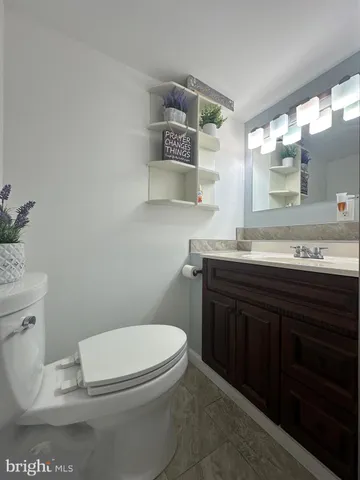a bathroom with a granite countertop toilet sink and mirror