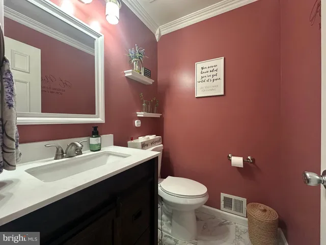 a bathroom with a toilet sink vanity and mirror