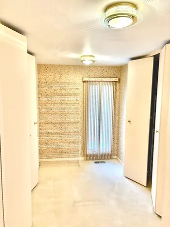 a view of a room with wooden floor a ceiling fan and a window