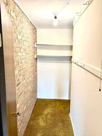 a view of a bedroom with wooden floor and cabinet