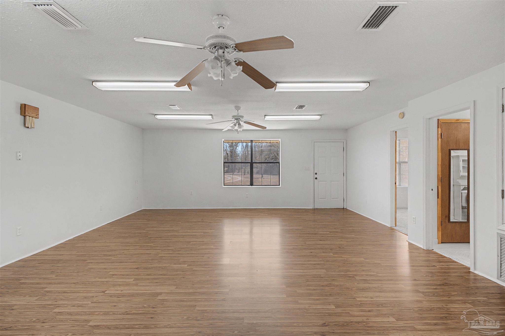 3401 Rocky Road Jay, FL 32565 - Photo 12 of 45 a view of an empty room with wooden floor ceiling fan