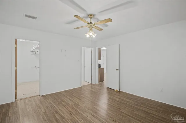a view of a livingroom with a ceiling fan & wooden floor