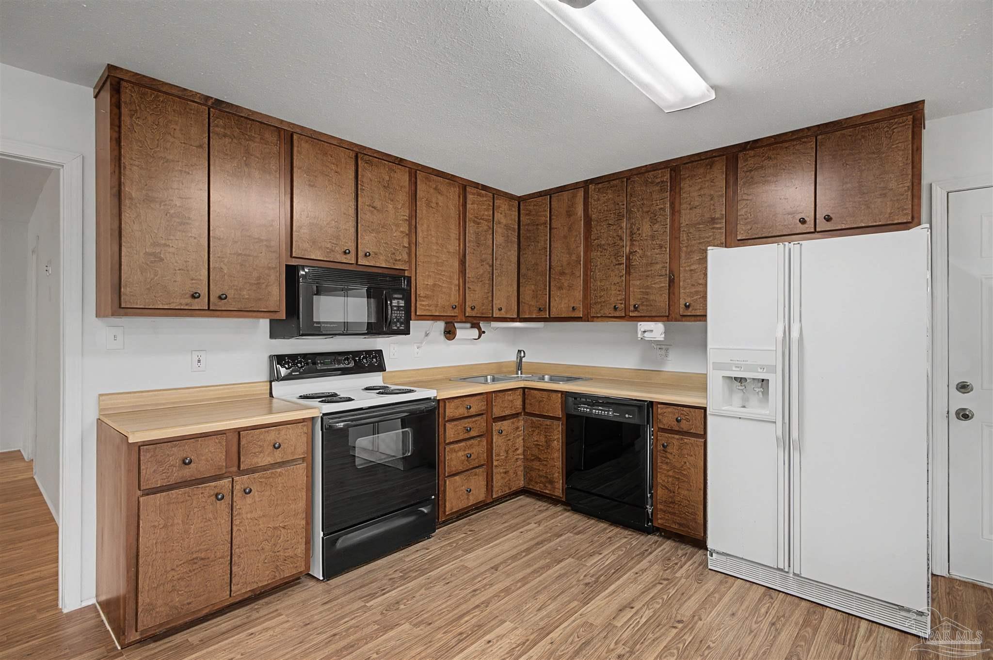 3401 Rocky Road Jay, FL 32565 - Photo 14 of 49 a kitchen with cabinets stainless steel appliances a sink and wooden floor