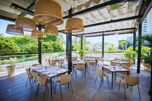 a view of a patio with a table chairs and a floor to ceiling window