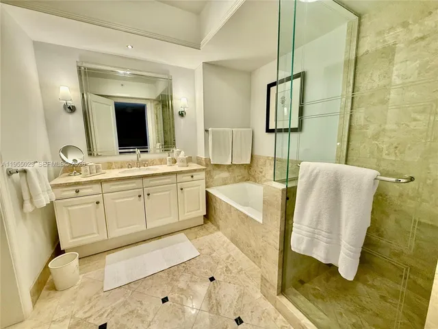 a bathroom with a tub sink and mirror