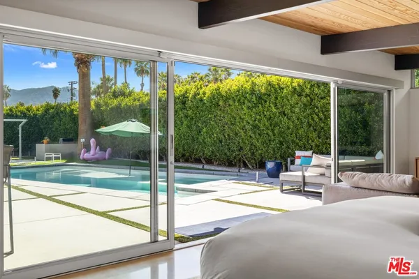 a bedroom with furniture and large windows