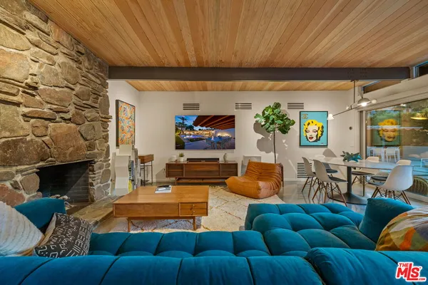 a living room with furniture a fireplace and a table