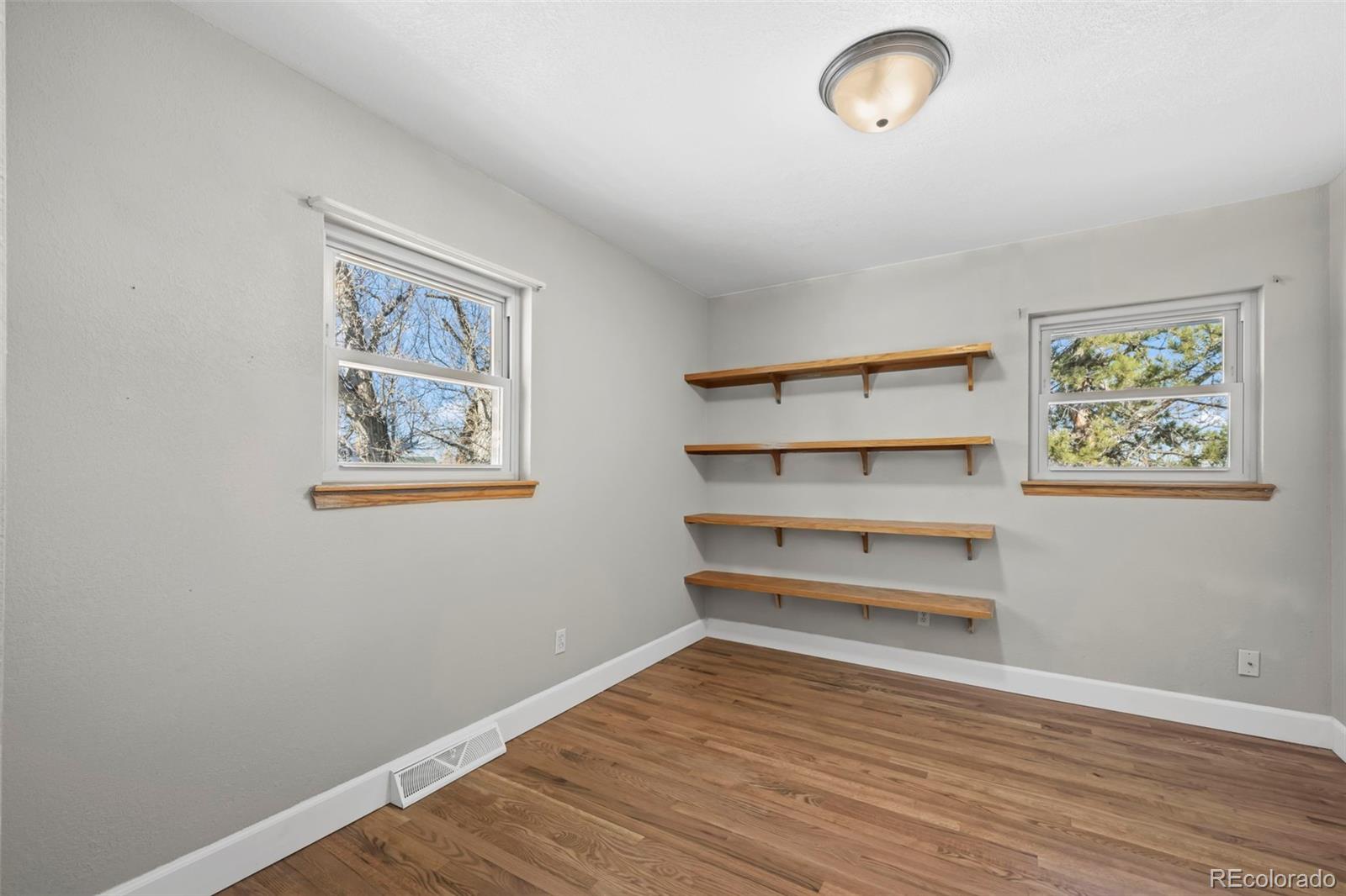 8213 Adams Way Denver, CO 80221 - Photo 14 of 22 a view of room with wooden floor and cabinet
