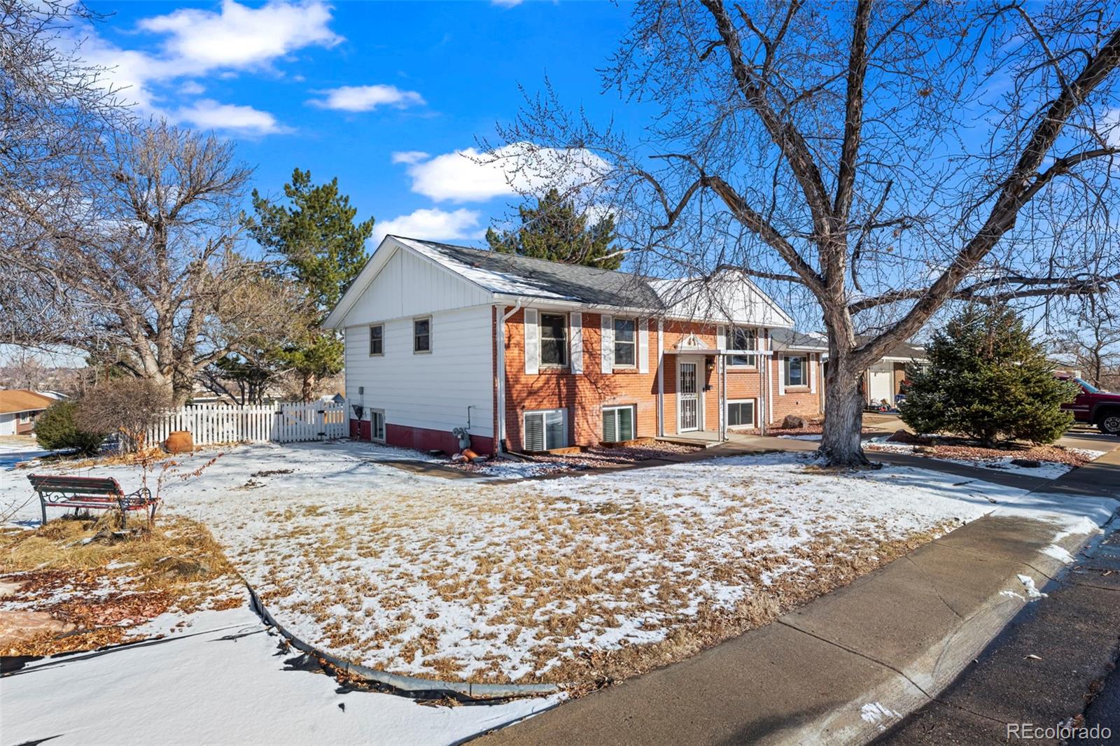 8213 Adams Way Denver, CO 80221 - Photo 2 of 22 a view of a house with a yard covered in snow