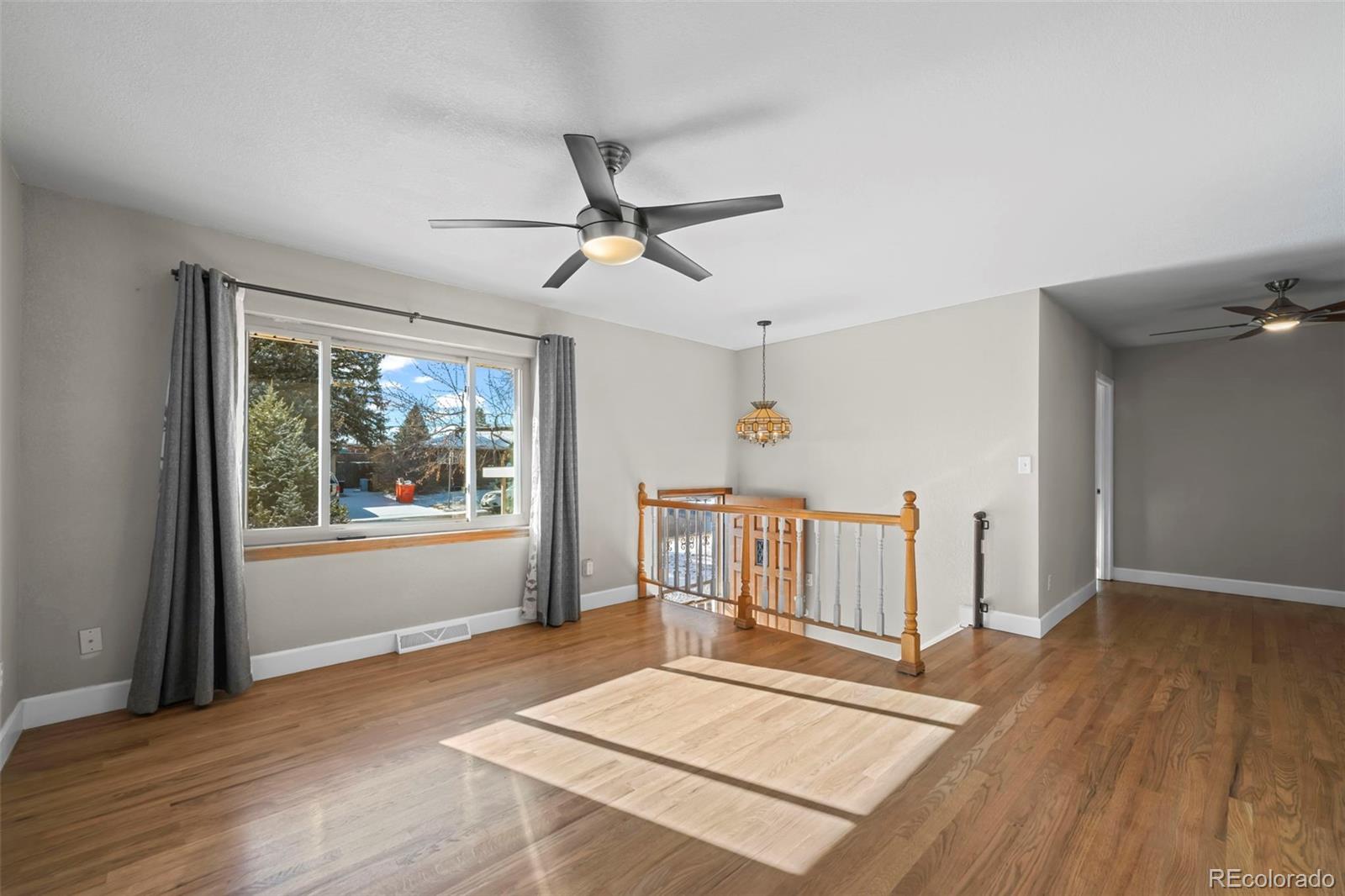 8213 Adams Way Denver, CO 80221 - Photo 4 of 22 a living room with wooden floors and a ceiling fan