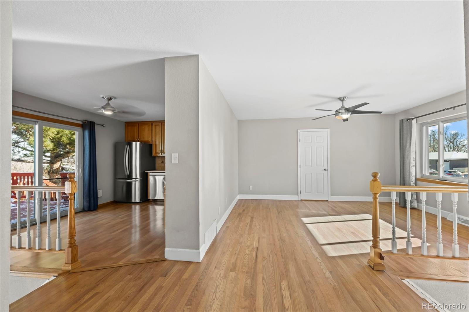 8213 Adams Way Denver, CO 80221 - Photo 5 of 22 a view of a livingroom with wooden floor and a ceiling fan