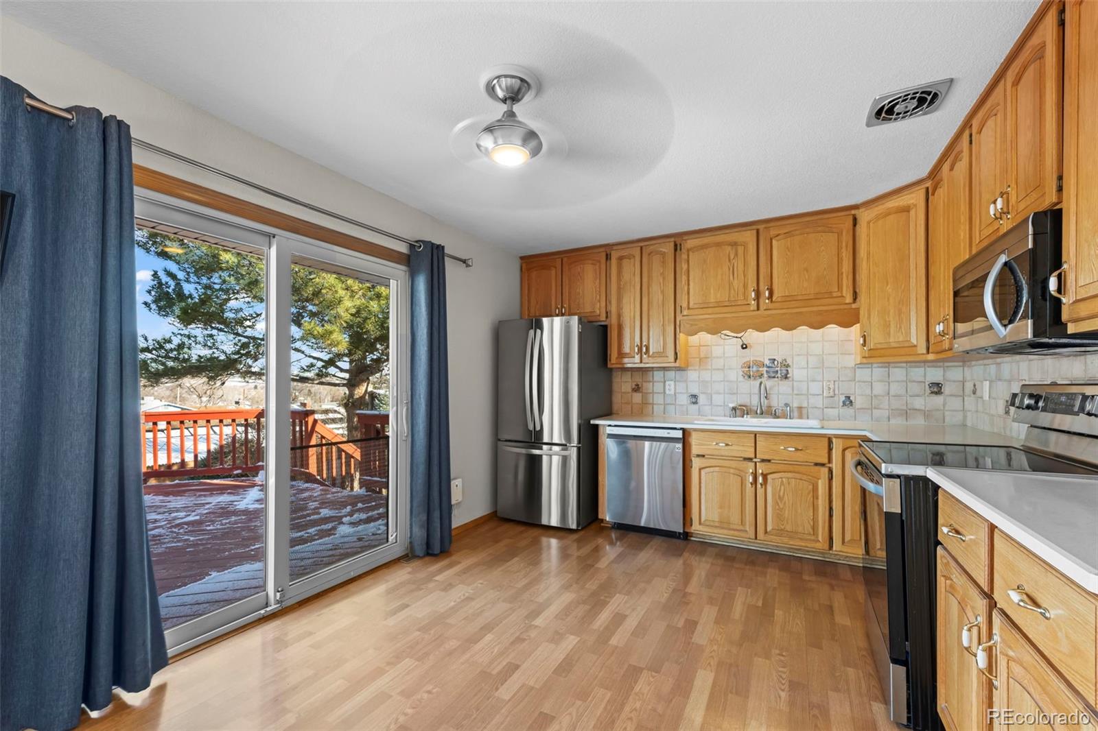 8213 Adams Way Denver, CO 80221 - Photo 6 of 22 a kitchen with stainless steel appliances granite countertop a refrigerator a sink dishwasher a stove and a oven with wooden floor
