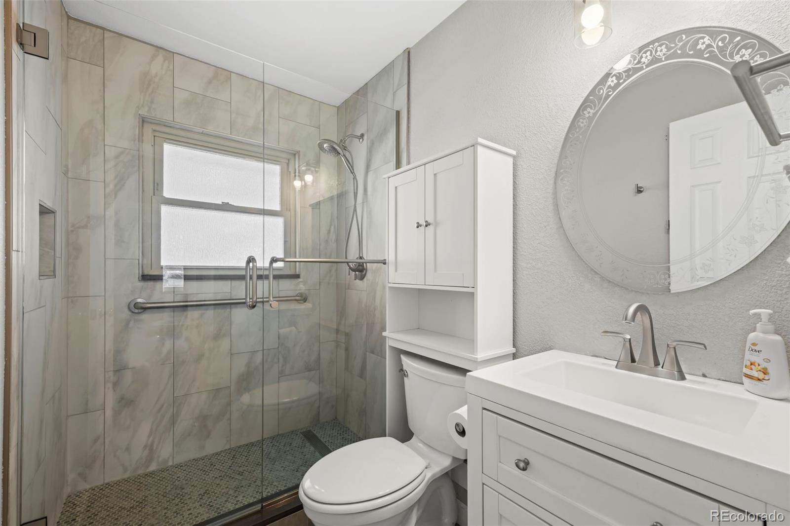 8213 Adams Way Denver, CO 80221 - Photo 10 of 22 a bathroom with a sink a toilet and shower