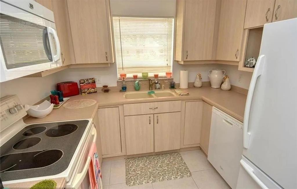1225 Northwest 21st Street, Unit 3507 Stuart, FL 34994 - Photo 14 of 18 a kitchen with a sink stove and cabinets