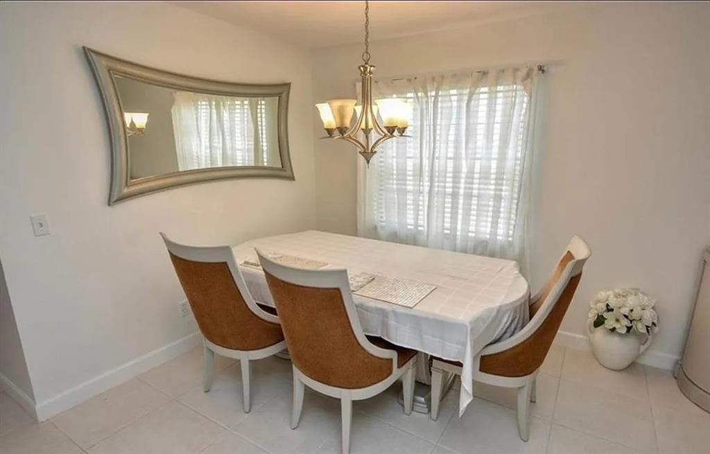 1225 Northwest 21st Street, Unit 3507 Stuart, FL 34994 - Photo 6 of 18 a view of a dining room with furniture and chandelier