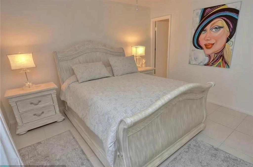 1225 Northwest 21st Street, Unit 3507 Stuart, FL 34994 - Photo 8 of 18 a bedroom with a bed and a lamp