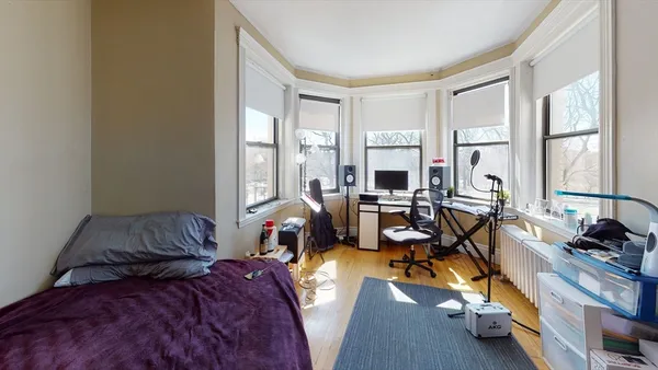 a bedroom with two beds and large windows