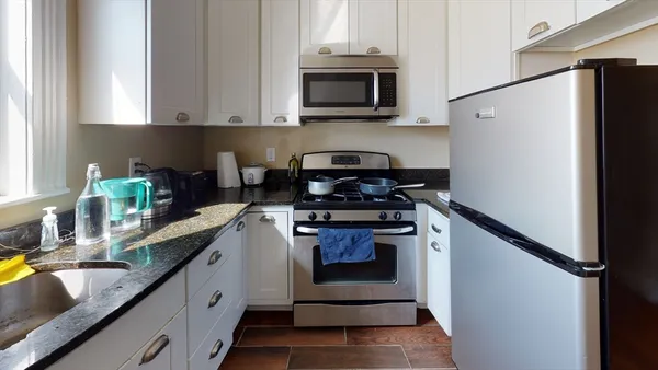 a kitchen with stainless steel appliances granite countertop a refrigerator sink and stove