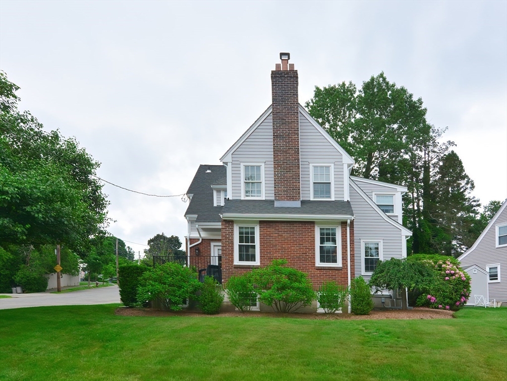 1133 Brook Road Milton, MA 02186 - Photo 1 of 40 a front view of a house with a yard and trees