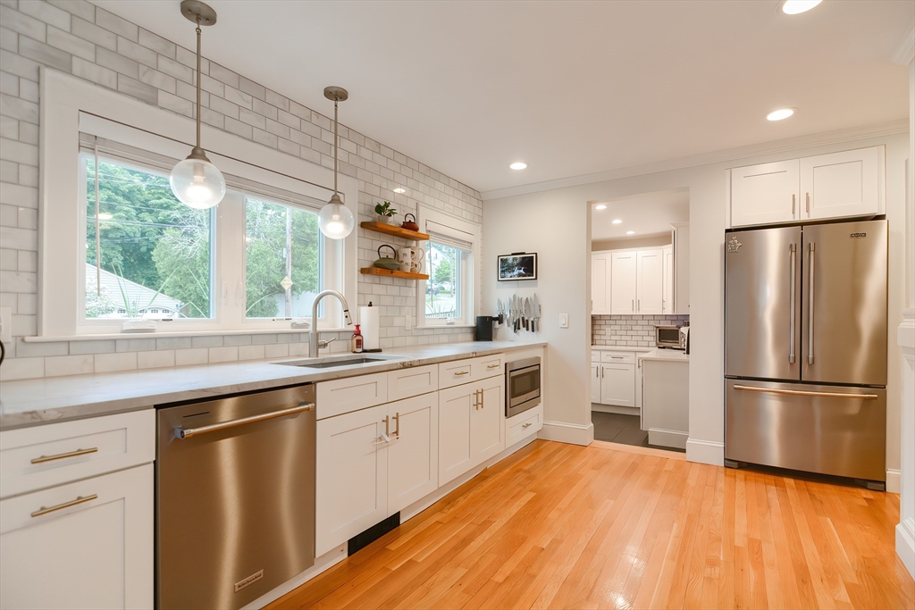 1133 Brook Road Milton, MA 02186 - Photo 20 of 40 a kitchen with a refrigerator a sink and dishwasher with wooden floor