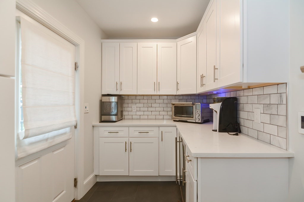 1133 Brook Road Milton, MA 02186 - Photo 26 of 40 a kitchen with a sink and white cabinets