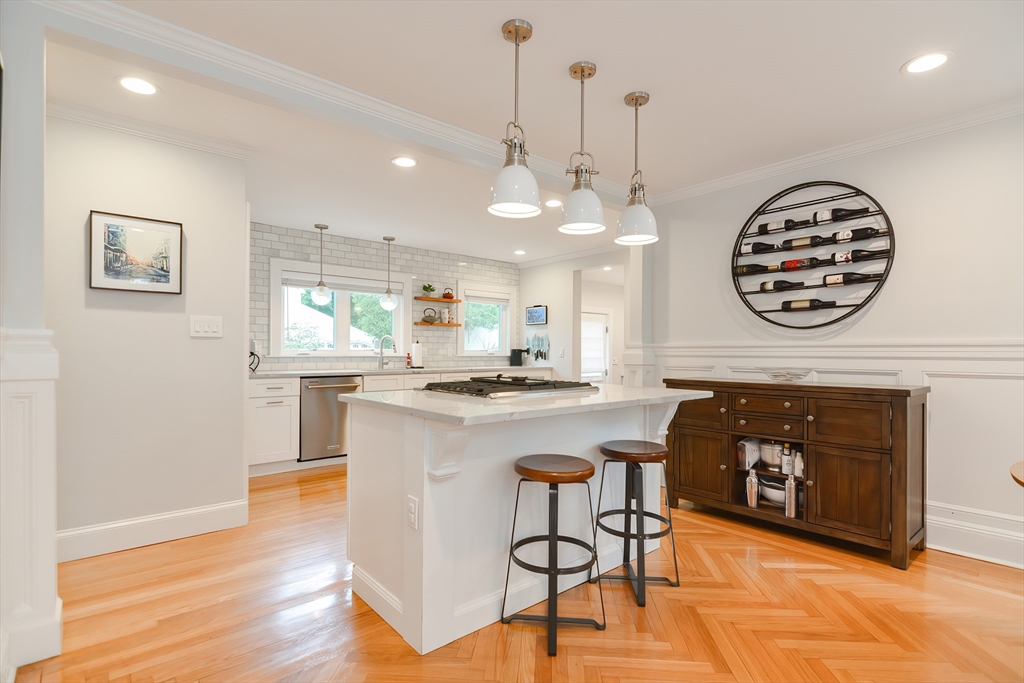 1133 Brook Road Milton, MA 02186 - Photo 27 of 40 a kitchen with kitchen island a stove a table and a fireplace