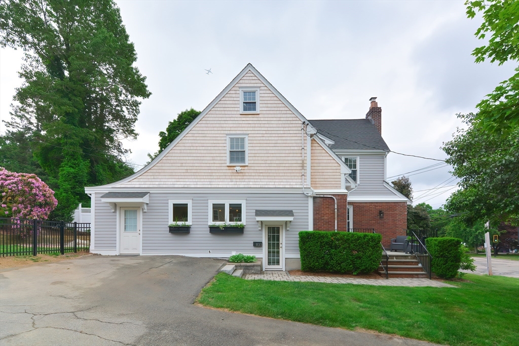 1133 Brook Road Milton, MA 02186 - Photo 3 of 40 a front view of a house with a yard and garage