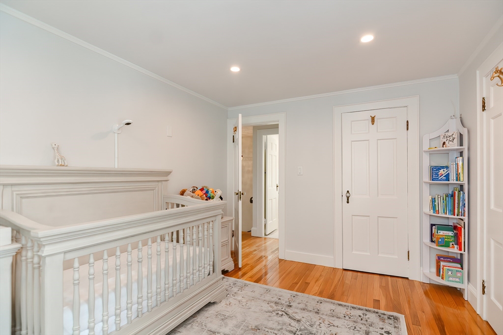 1133 Brook Road Milton, MA 02186 - Photo 36 of 40 a bedroom with baby crib and a wooden floor