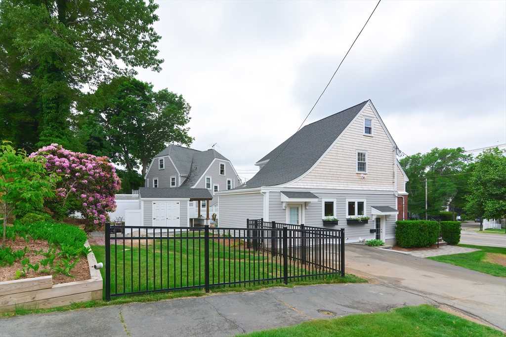 1133 Brook Road Milton, MA 02186 - Photo 6 of 40 a view of a white house next to a yard with big trees