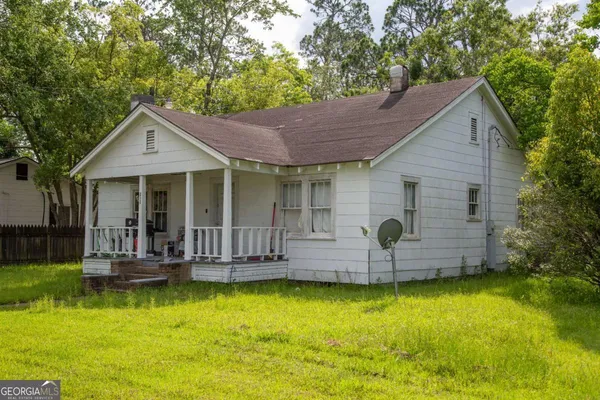 a front view of house with a garden