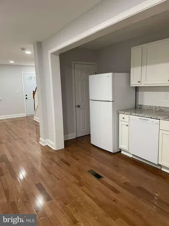a view of kitchen with refrigerator and cabinets