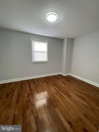 a view of a room with wooden floor and a window
