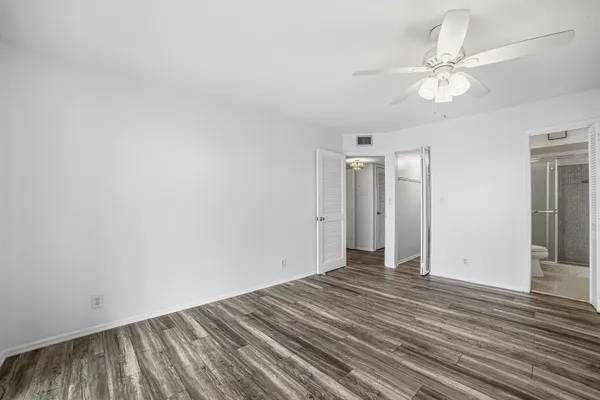 a view of a room with wooden floor and a ceiling fan