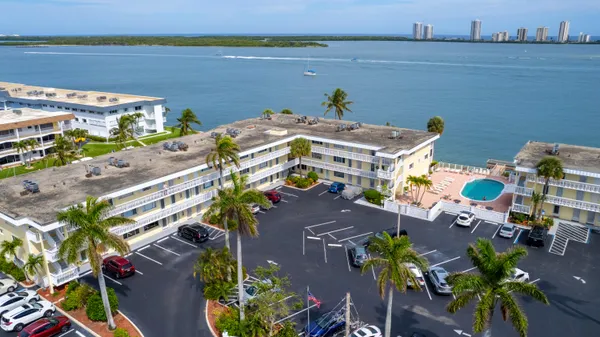 a view of a palm trees front of house with wooden fence
