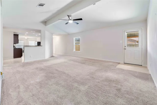 an empty room with windows and fan