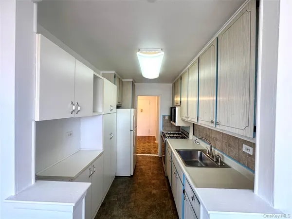 a kitchen with granite countertop a sink a stove and refrigerator